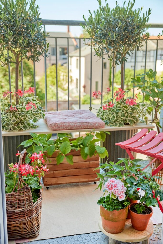 A balcony garden is filled with plants and flowers.